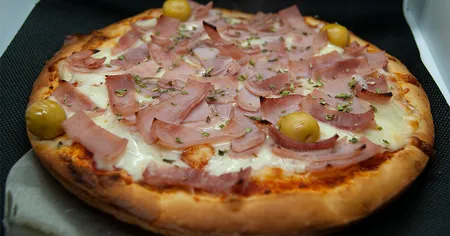Auténtica pizza argentina, con masa crujiente y toppings frescos, que te transportarán a Buenos Aires.